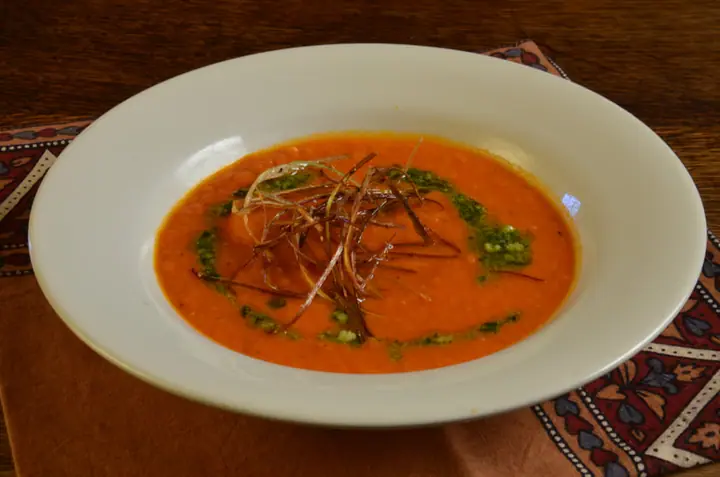 A bowl of tomato soup with basil oil